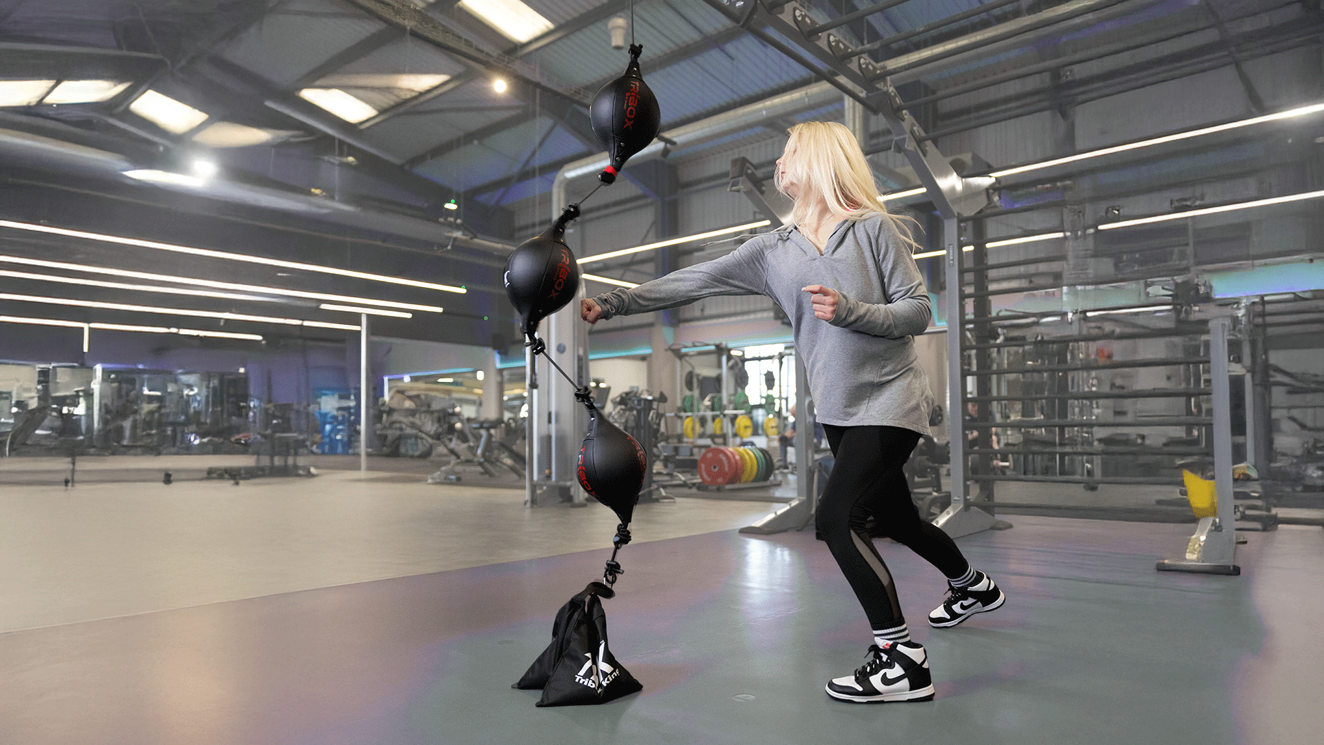 girl in gym punching a fitness ball called Triboxking by TBKFiT