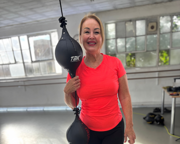 Lady trains with Triboxking fitness system in a hall