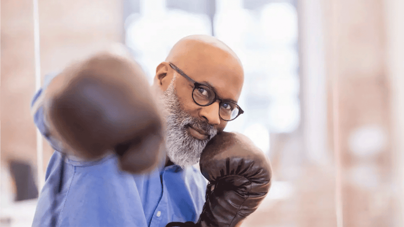Man wearing boxing gloves in a blurred indoor setting