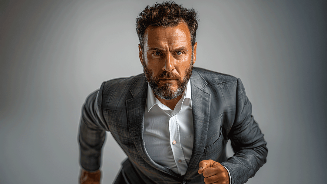 Man in a gray suit with a serious expression on a gray background